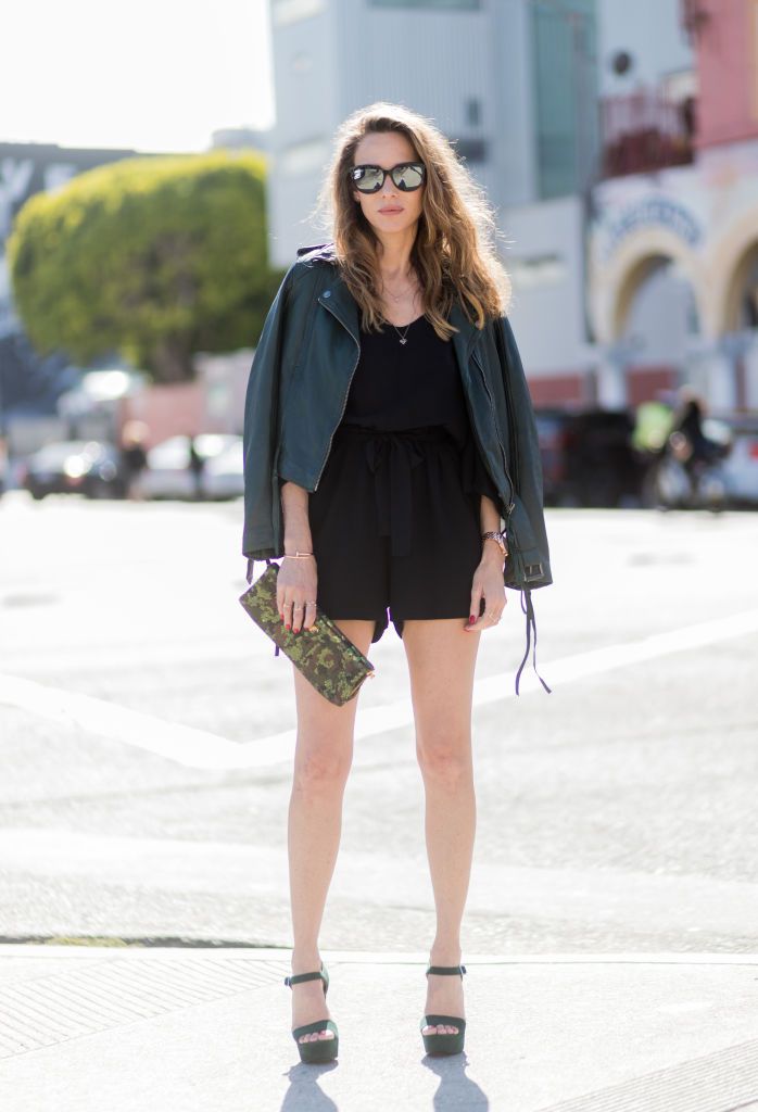 Kvinna in romper and leather jacket for summer fashion
