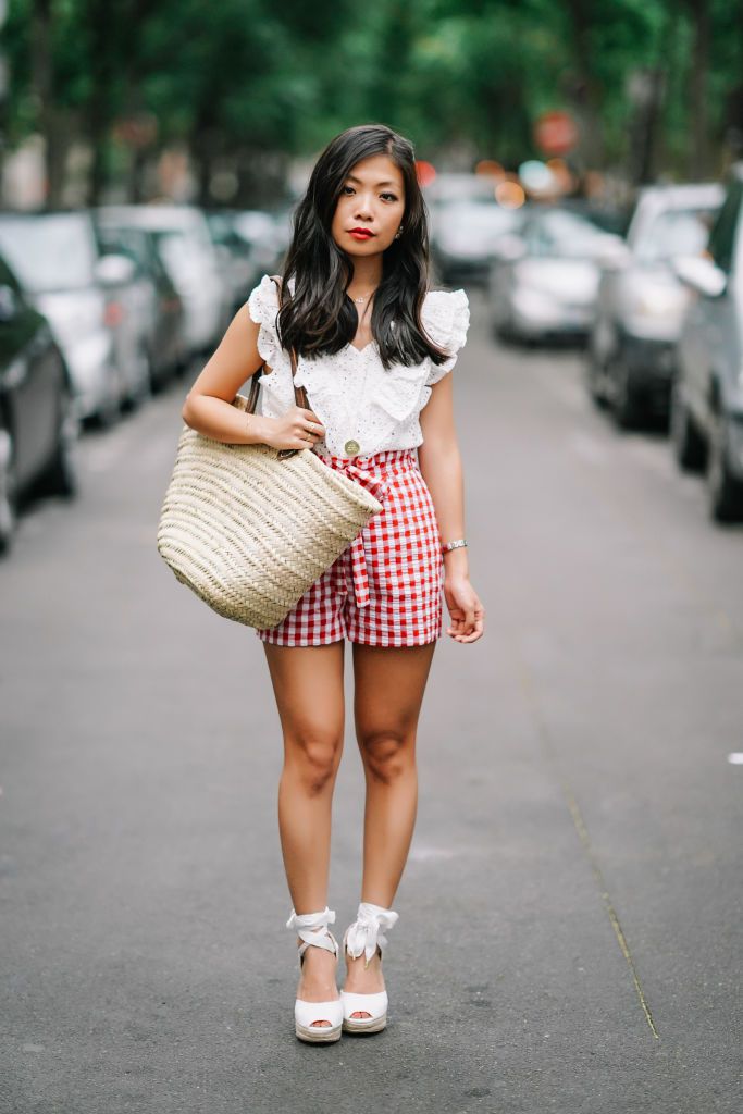 Kvinna in ruffled top and gingham print shorts for summer fashion
