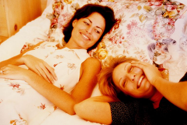 Două women relaxing on bed, portrait