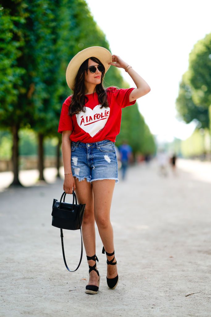 Modern summer outfit in denim shorts and a hat