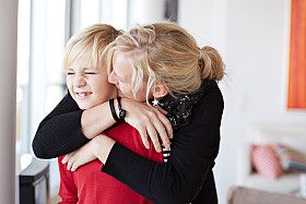 A mom hugs her son good-bye.