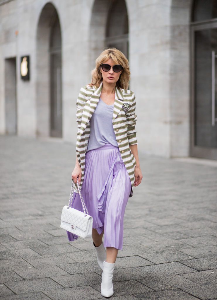 महिला in striped jacket and purple pleated skirt