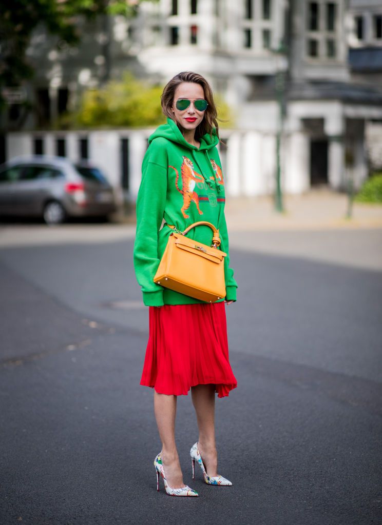 सड़क style fashion woman wearing a Gucci sweatshirt and pleated skirt