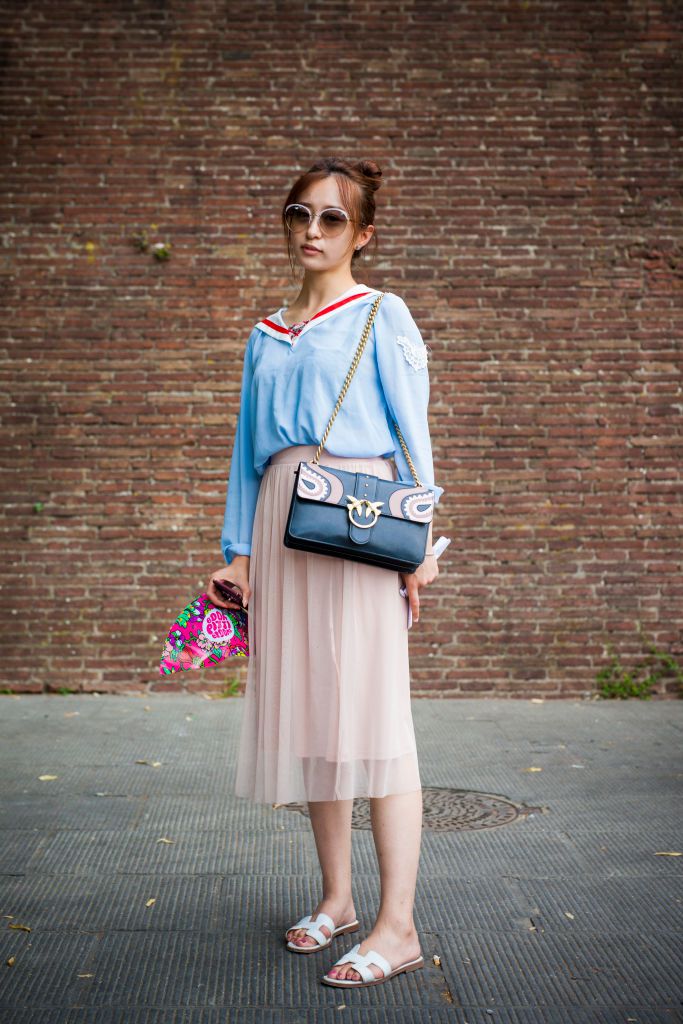 महिला wearing blue blouse and pink pleated skirt