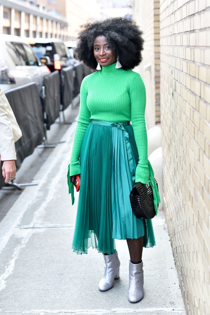 אִשָׁה wearing green top and green pleated maxi skirt