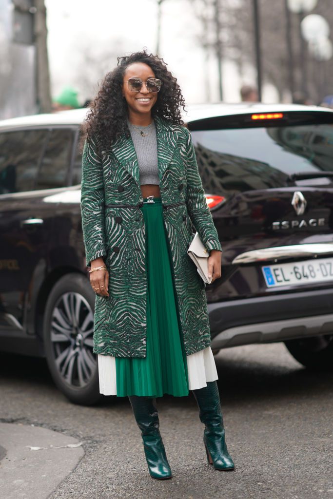 רְחוֹב style woman in green pleated skirt and patterned coat