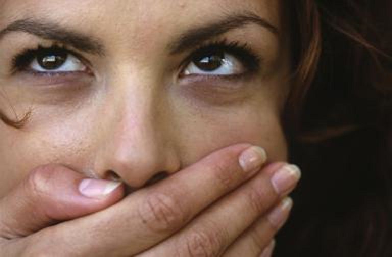 A woman covers her mouth with her hand