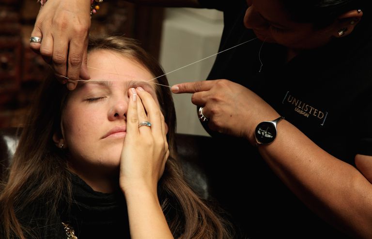 А woman has her eyebrows threaded at the Designer Couture Trunk Show hosted by Noelle Reno at The Collection in London, England.