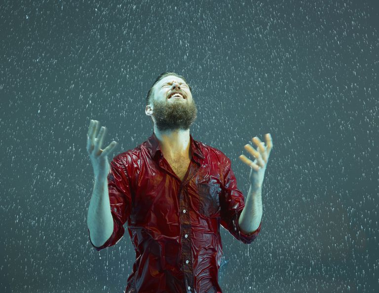en man laughing in the rain.