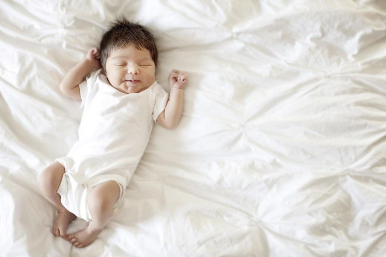 en newborn baby lying on a bed