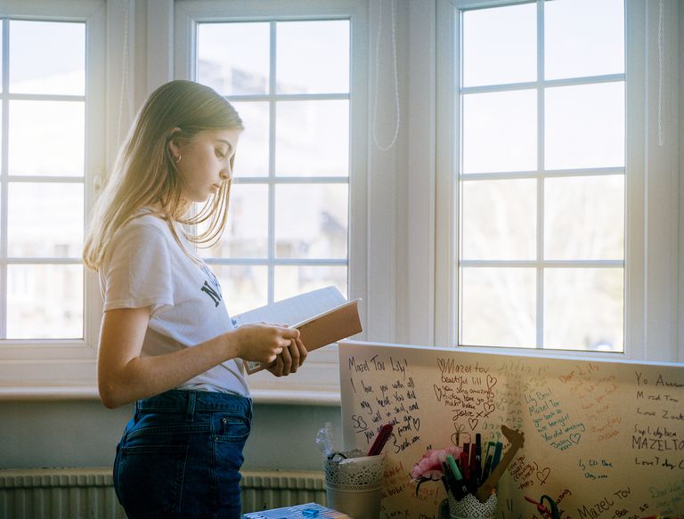 tonåring girl reading notebook