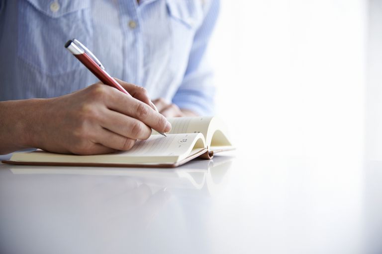 kvinna writing in notebook