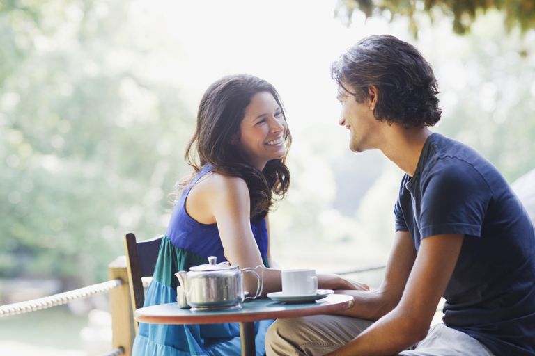 मुस्कराते हुए couple having tea outdoors