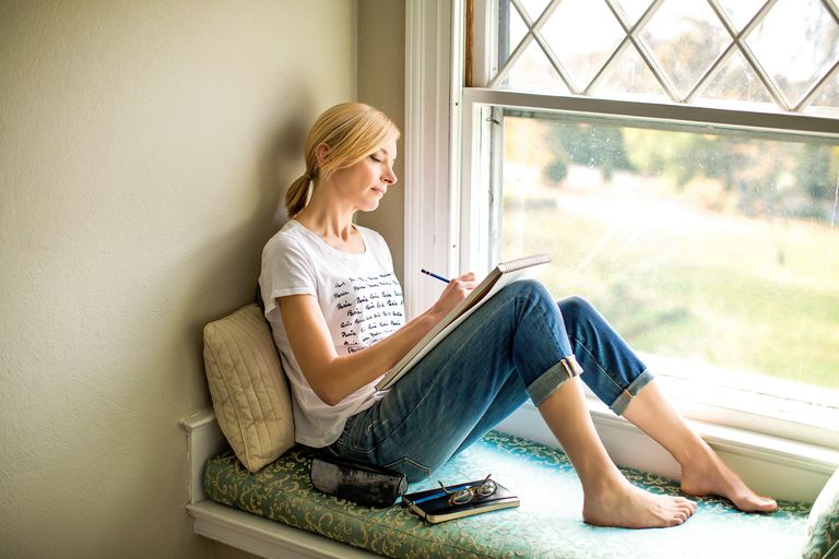nő journaling in window
