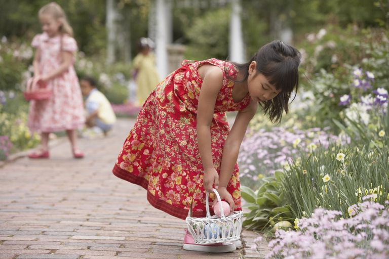 צָעִיר girls gathering Easter eggs in garden