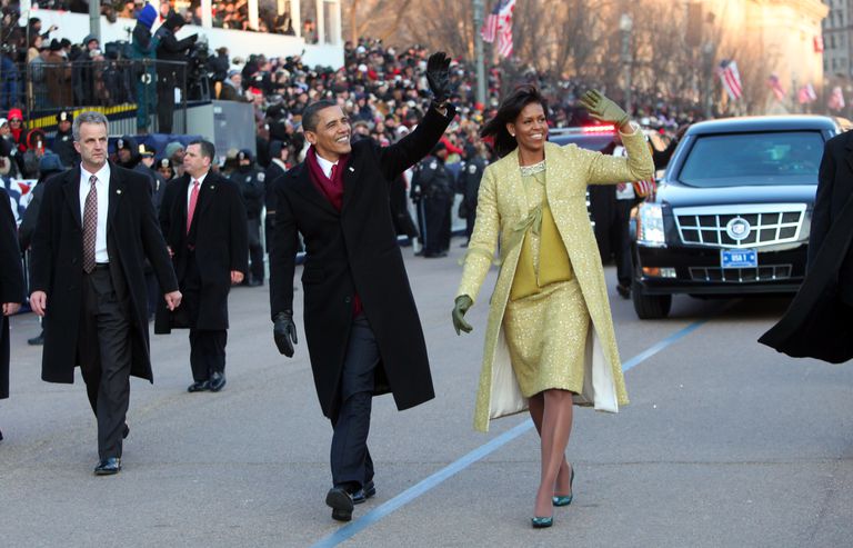 ברק and Michele Obama waving in street