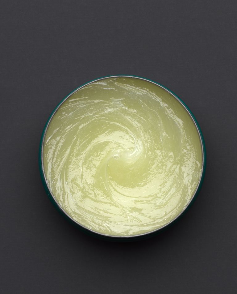 An open tin of vaseline on grey background