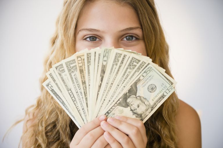 युवा girl holding money.