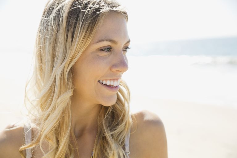 Skön woman smiling on beach