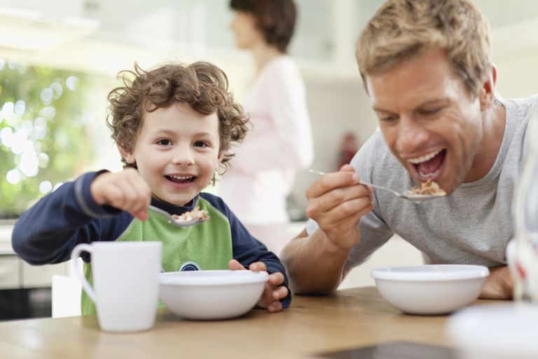 पिता and son eating cereal
