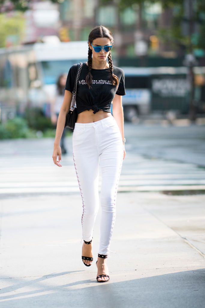 Kadın wearing white jeans and black t-shirt