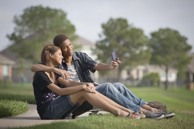 मिश्रित race couple taking self-portrait with cell phone