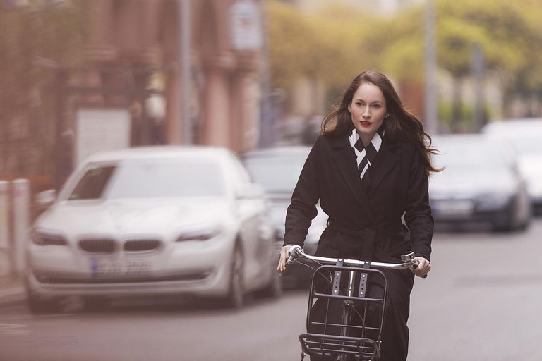 kvinna in black coat riding bicycle