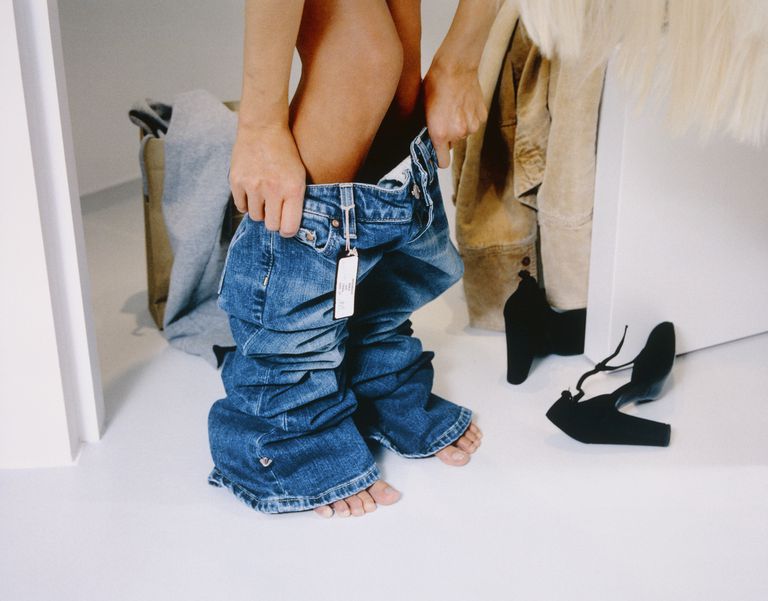 אִשָׁה trying on jeans in fitting room