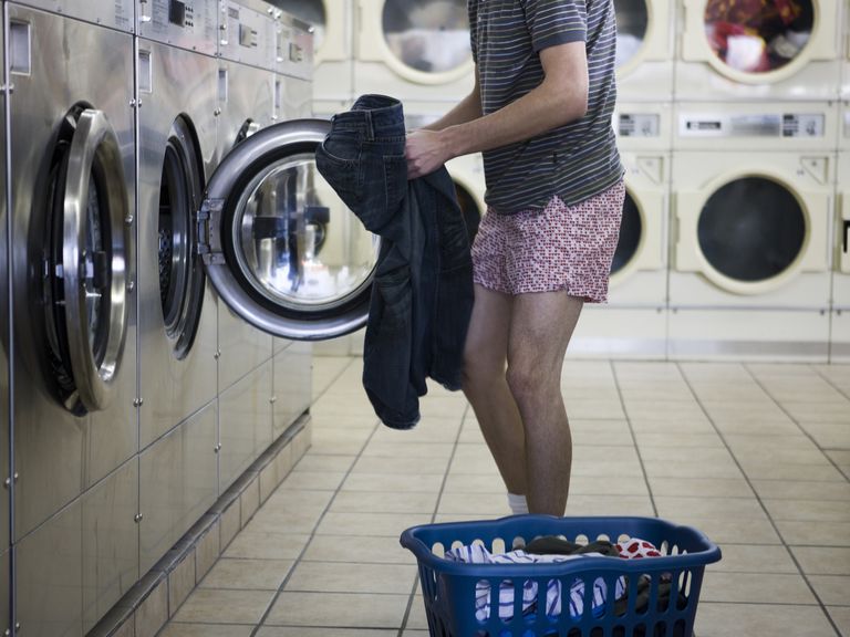 איש taking jeans off before putting them in laundry