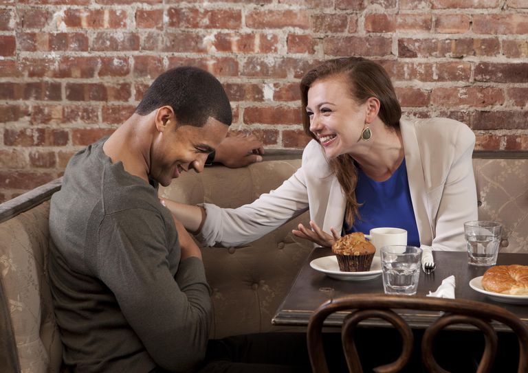 Пар laughing at coffee shop