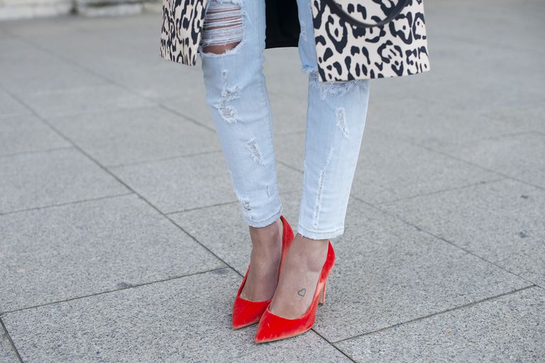क्लोज़ अप of red pumps worn with skinny jeans