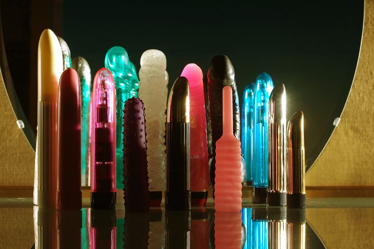 א collection of vibrators and dildos of different colours and shapes all standing.