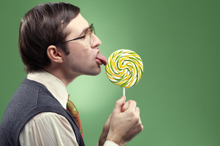 आदमी licking a giant lollipop