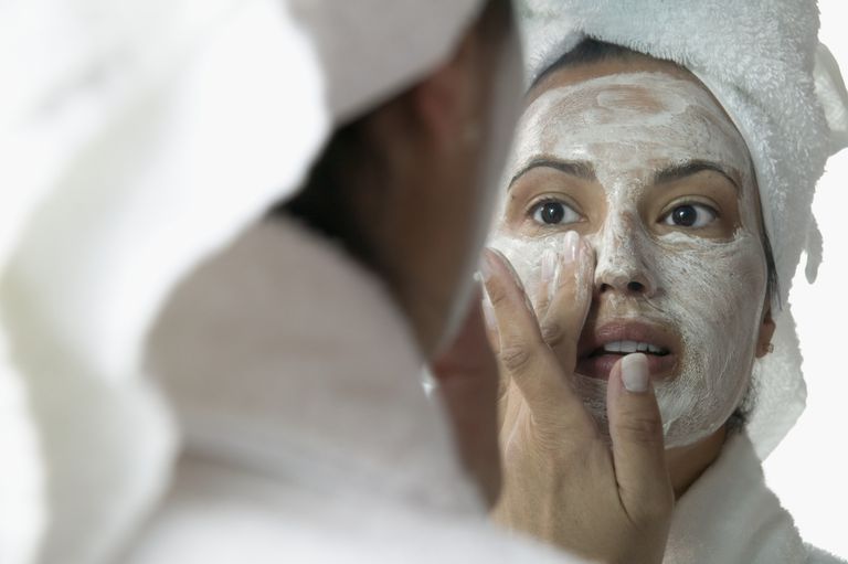 Жена applying face masks