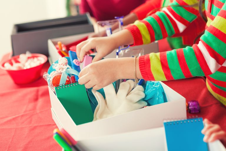נְקֵבָה child filling Christmas donation boxes for children in need