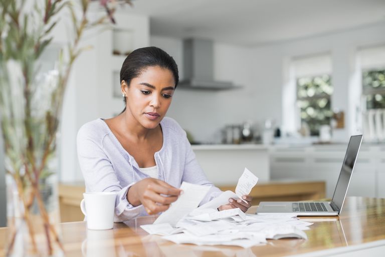 महिला paying bills online at home