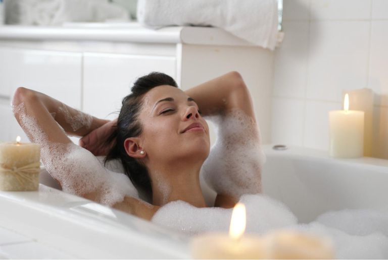 युवा woman in bubble bath, smiling
