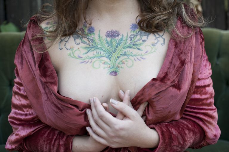 жена in bathrobe displaying chest tattoos