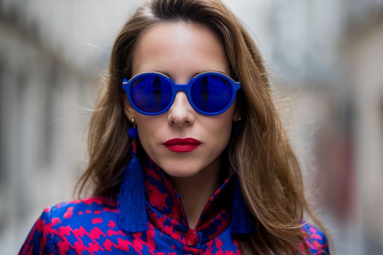 महिला wearing blue sunglasses and blue tassel earrings
