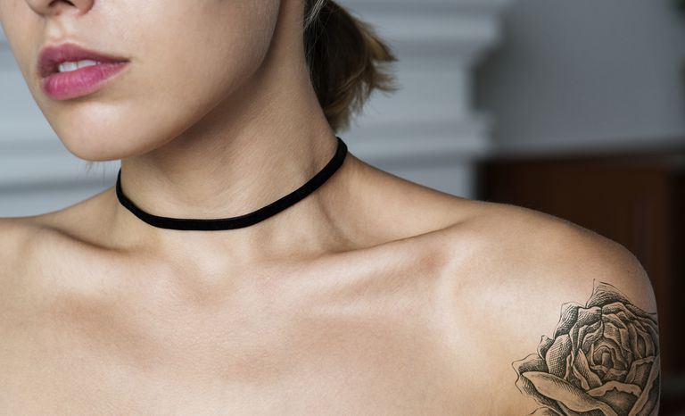 אִשָׁה with rose tattoo on shoulder