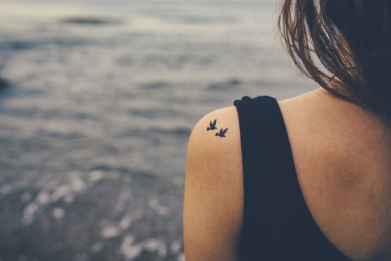หญิง with two birds tattooed on shoulder
