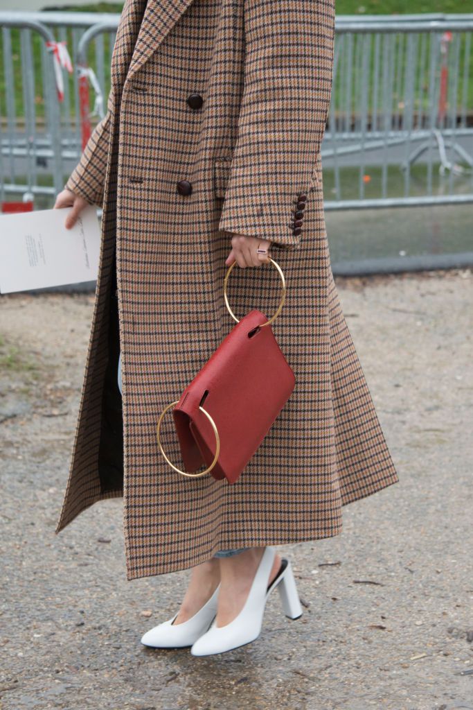 Улица style in a plaid coat and red purse