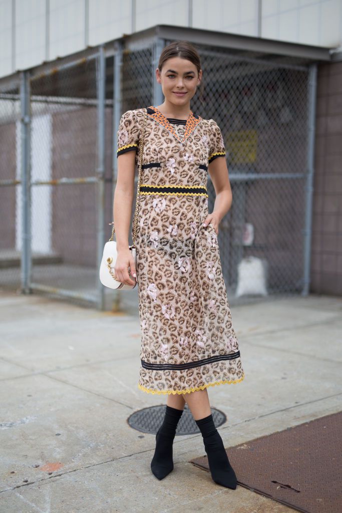 Kadın wearing a leopard print dress and ankle boots