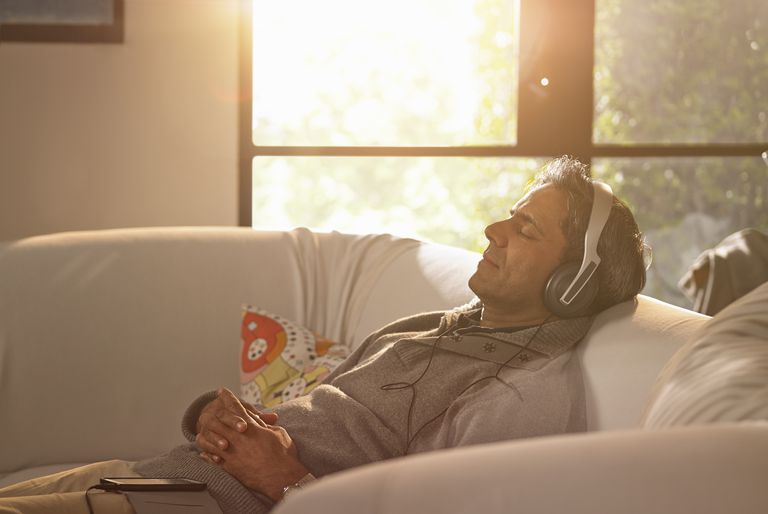 א man relaxing at home listening to music.