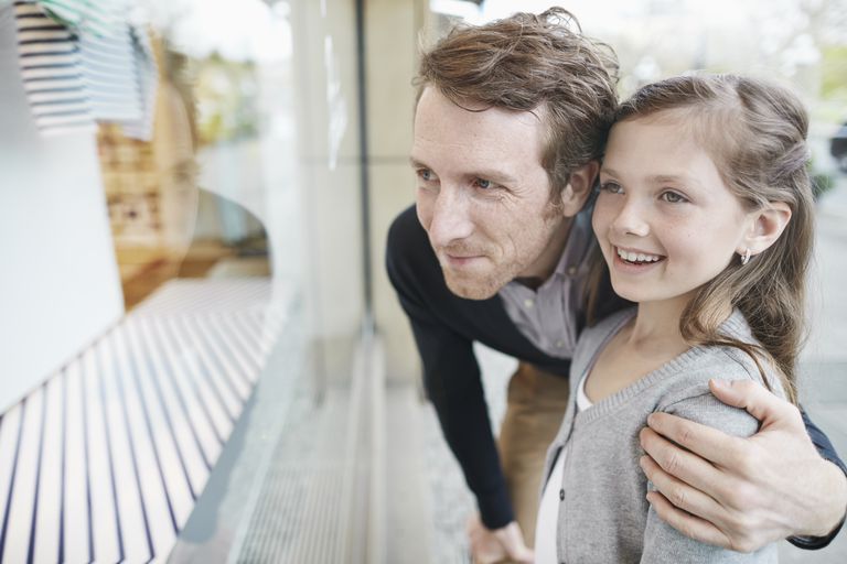 Apa and daughter looking in a store window.