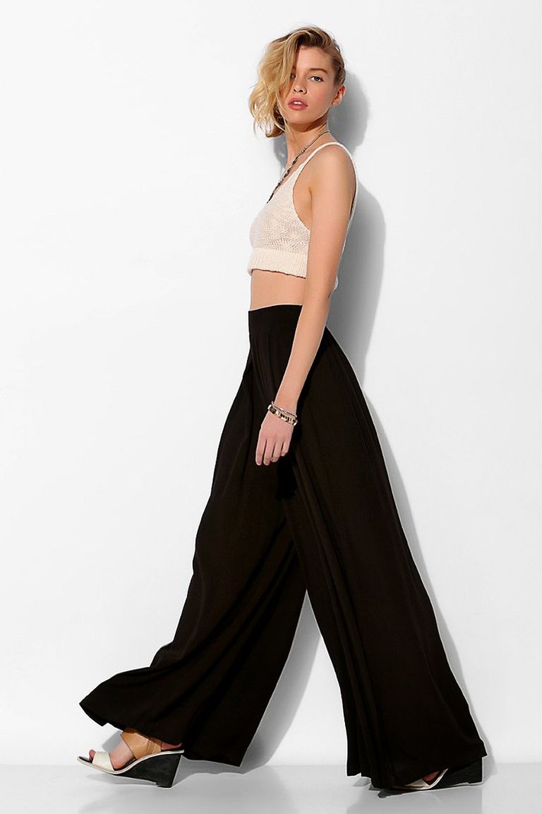 Model wearing cropped cream tank top and black palazzo pants.