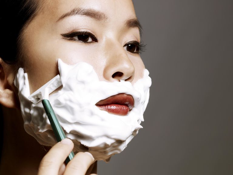 Млади Asian woman shaving
