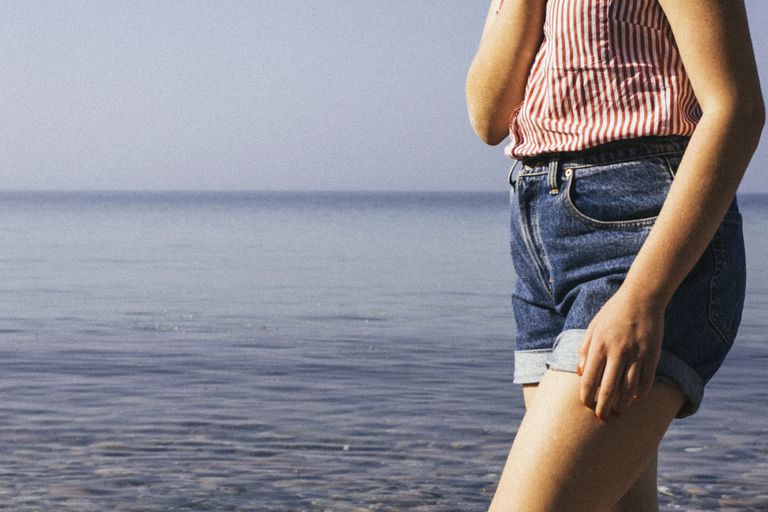 महिला in jean shorts by lake or ocean