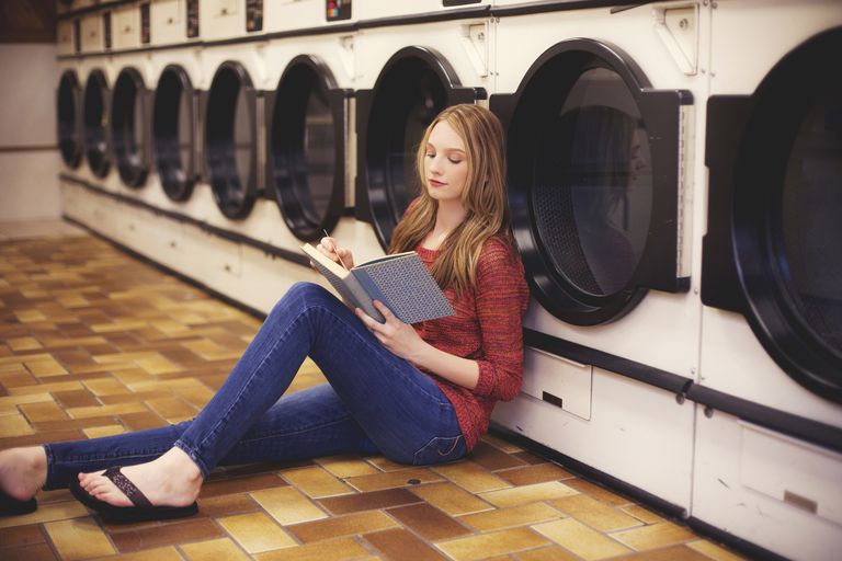 Жена reading at laundromat