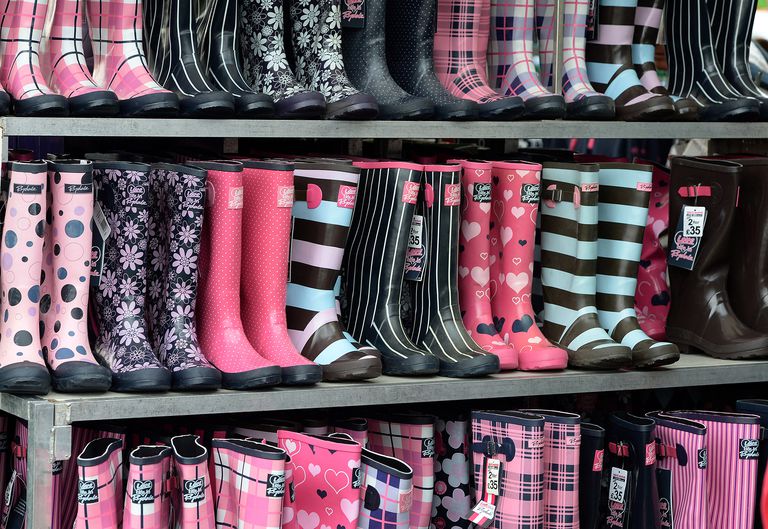 שורות of colorful, patterned and print rain boots at a market.